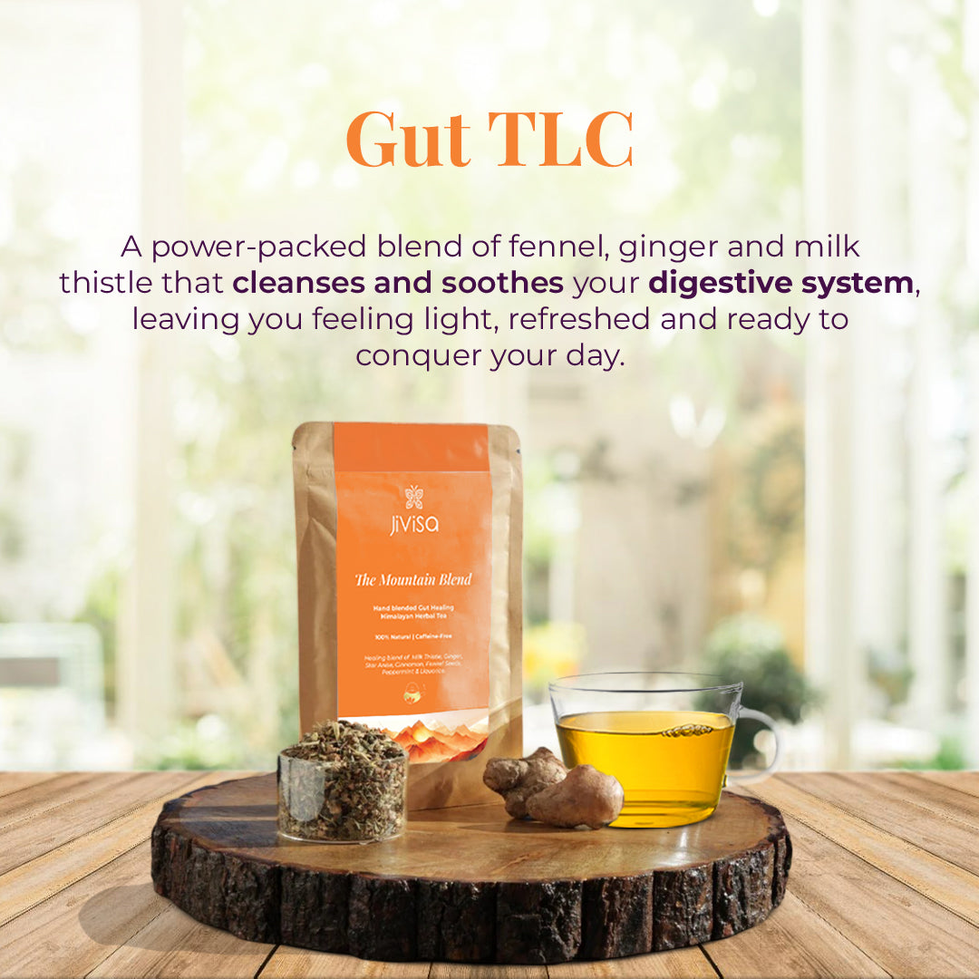 The image featuring a Pouch of JiViSa- The Mountain Blend Hand blended Healing Himalayan Herbal Tea with a cup of herbal tea placed on a wooden platter. The tagline reads "Gut TLC" with a text describe the Mountain Blend as a power-packed of fennel, ginger and milk thistle that cleanses and soothes your digestive system leaving you feeling light, refreshed and ready to conquer your day.