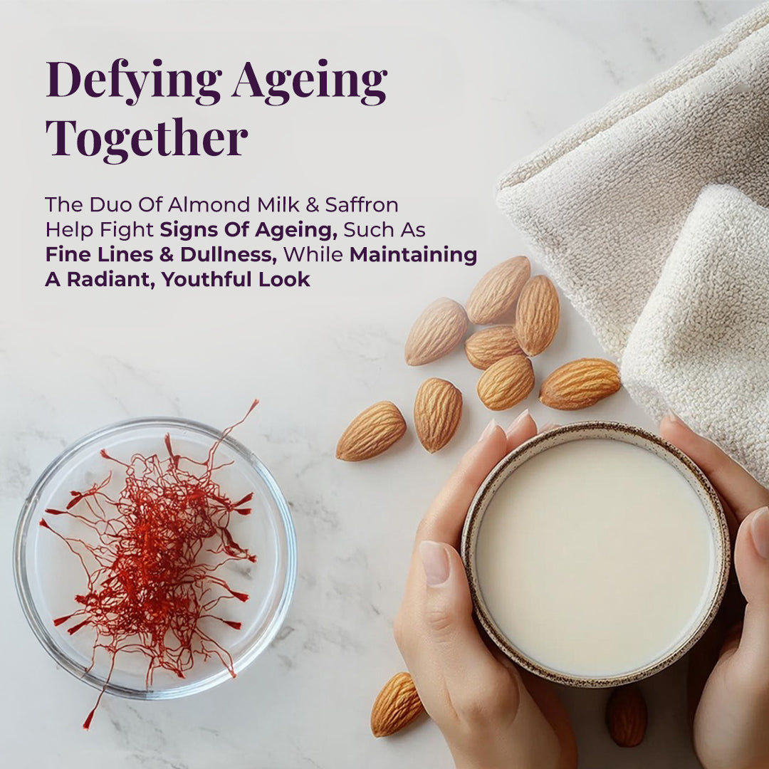 Image focuses on the anti-aging benefits of JiViSa Almond Milk & Saffron Ayurvedic Soap, with the headline "Defying Ageing Together." It emphasizes the effect of its key ingredients: The Duo of Almond Milk & Saffron Help Fight Signs Of Ageing, Such As Fine Lines & Dullness, While Maintaining a Radiant, Youthful Look. The visual composition includes a dish filled with vibrant red saffron threads, a bowl of almond milk being held by hands, scattered whole almonds, and soft, folded towels in the background.