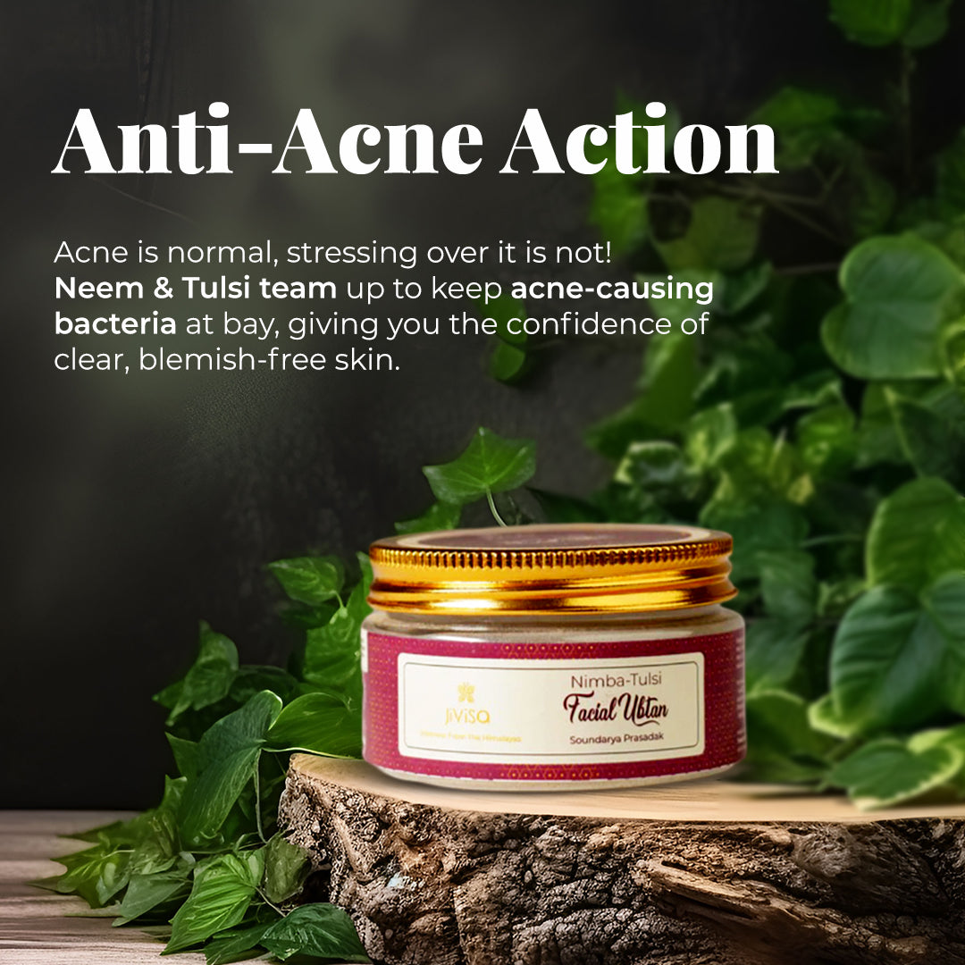 The tagline highlights "Anti-Acne Action" with the text Acne is normal, stressing over it is not! Neem & Tulsi team up to keep acne-causing bacteria at bay, giving you the confidence of clear, blemish-free skin. Below the text there is a jar of JiViSa- Nimba Tulsi Facial Ubtan with a golden lid and a pink label. The jar sits on a piece of wood, surrounded by green leaves, against a dark background.