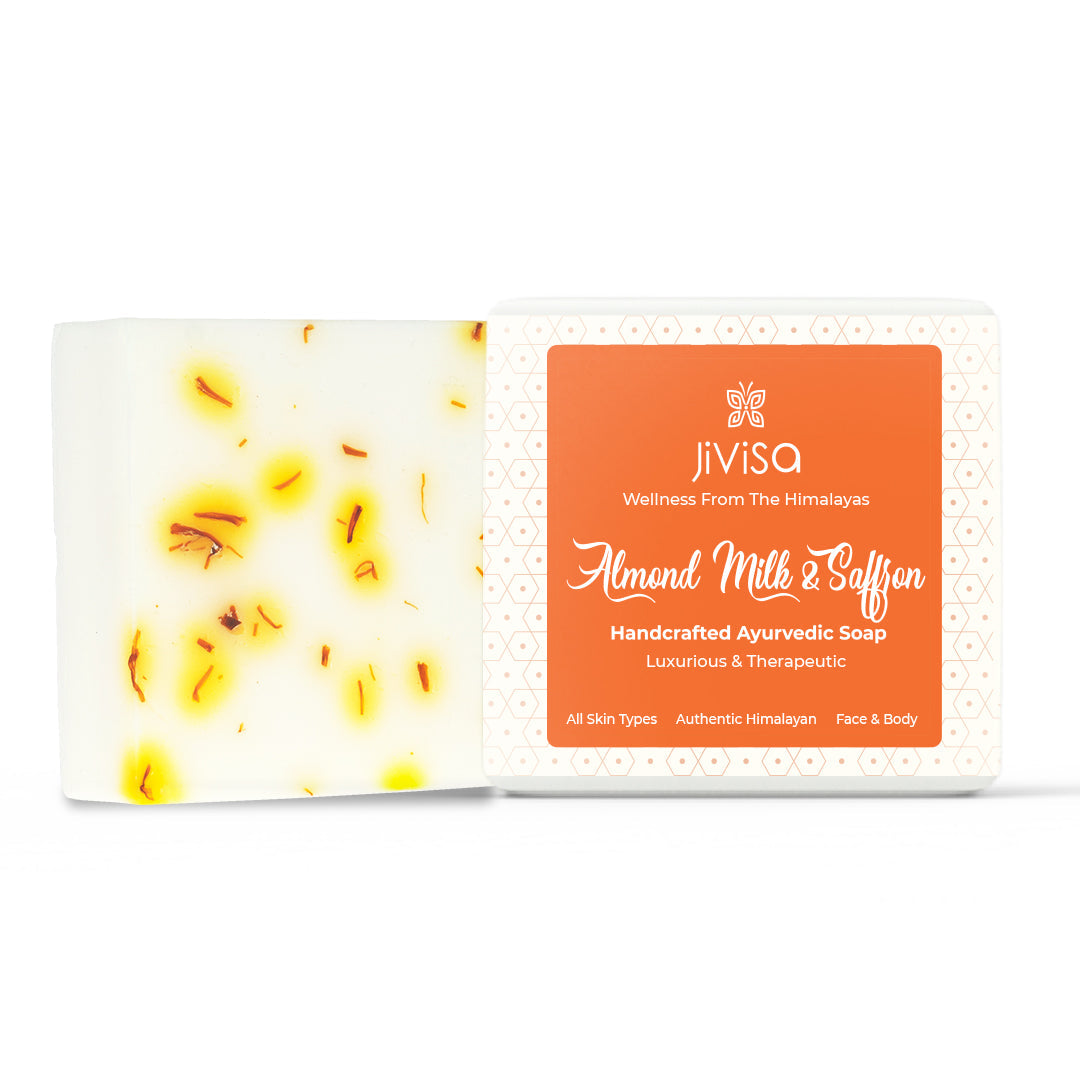JiViSa Almond Milk & Saffron Handcrafted Ayurvedic Soap with visible saffron strands in the soap bar and orange label packaging. The packaging highlights key USPs like “Luxurious & Therapeutic,” “All Skin Types,” and “Authentic Himalayan.
