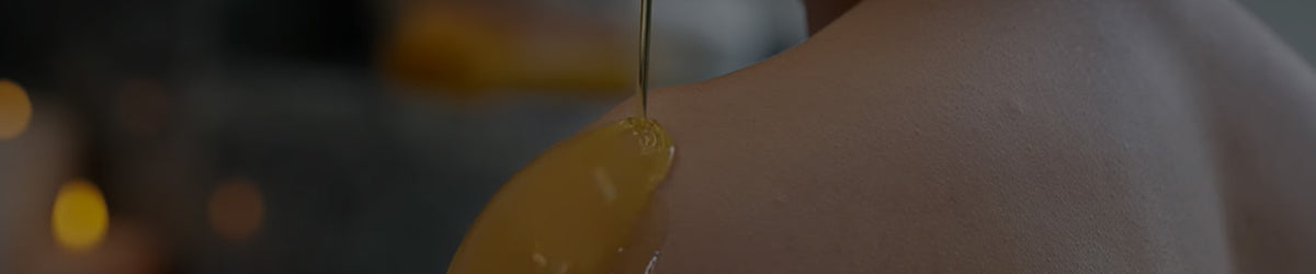 Close-up of oil being poured onto skin.