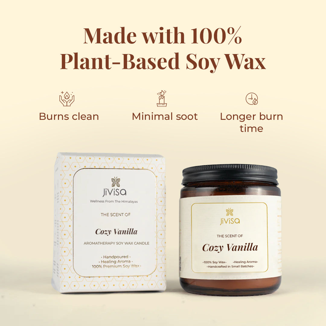 This image features both JiViSa Cozy Vanilla candle amber glass jar and its elegant white and gold-printed outer box against a soft beige background. The text at the top reads: "Made with 100% Plant-Based Soy Wax." Three icons below highlight: "Burns clean," "Minimal soot," and "Longer burn time." The box and jar both label reads: "JiViSa – The Scent of Cozy Vanilla – Aromatherapy Soy Wax Candle – Handpoured • Healing Aroma • 100% Premium Soy Wax."