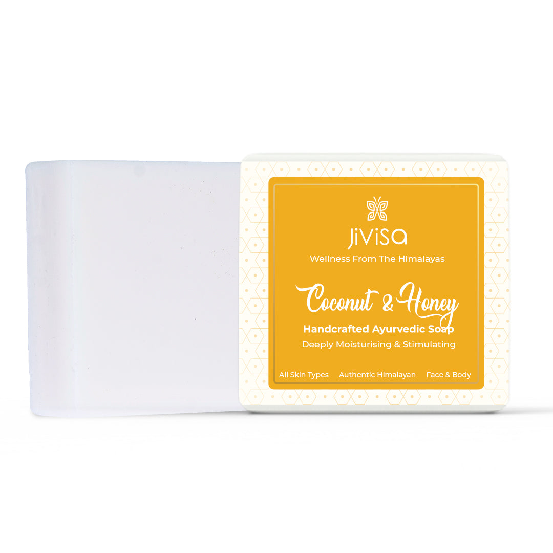 JiViSa Coconut & Honey Ayurvedic Handmade Soap bar placed beside its packaging box, front view of the packaging with bright honey-yellow label. Text on the label reads: “JiViSa Wellness from the Himalayas Coconut & Honey Handcrafted Ayurvedic Soap"– Deeply Moisturising & Stimulating. Bottom strip mentions: “All Skin Types | Authentic Himalayan | Face & Body.” Soap bar appears smooth and white.