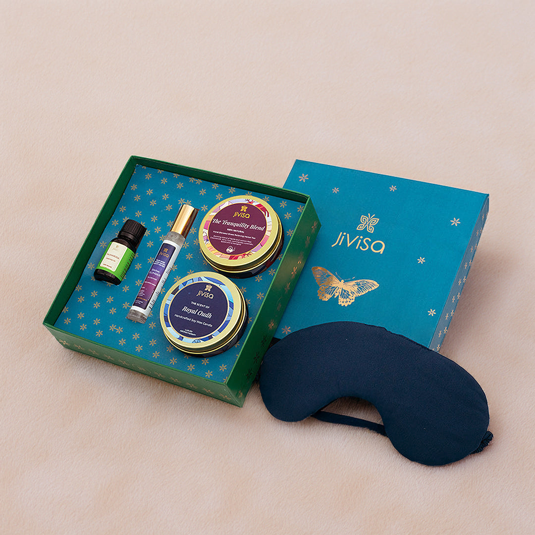 JiViSa Dreamscape Relaxation Gift Set is a thoughtfully curated wellness box designed to calm the senses and promote restful sleep. It features the JiViSa Tranquility Blend Stress Relief Herbal Tea, the Royal Oudh Premium Soy Wax Candle, a bottle of Palmarosa Essential Oil, the soothing Raina Slumber Pillow Mist, and a soft eye mask. Elegantly packed in a luxurious blue butterfly-themed box, this set is perfect for gifting or indulging in your own nightly relaxation ritual.