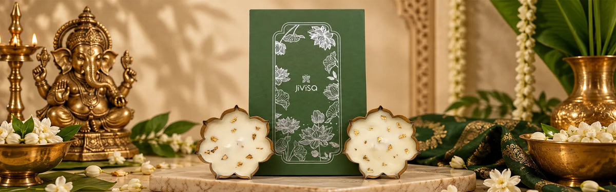 JiViSa Urli gift box with two gold-flecked lotus-shaped candles, styled beside a Ganesha idol and marigold flowers for Ganesh Chaturthi.