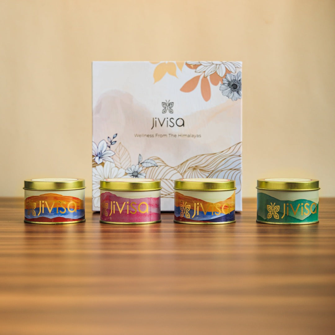 JiViSa Premium Loose Leaf Tea and Soy wax Candle Gift Box. Four round tins of JiViSa candles and herbal tea blends arranged in a front of the gift box.