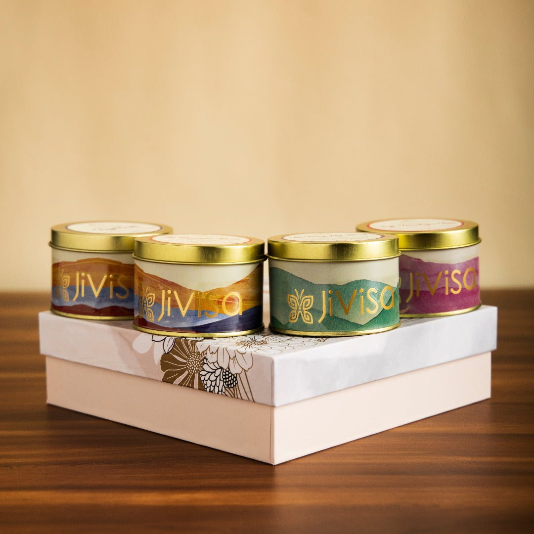 JiViSa aromatic set of four handcrafted soy wax candles including calming Soft Lavender to ease stress, warm and woody Royal Oudh for a touch of Arabian luxury, romantic Soft Himalayan Rose, and refreshing Himalayan Lemongrass all in elegant gold tins placed over the floral JiViSa Luxury Soy Wax Candle Gift Box.