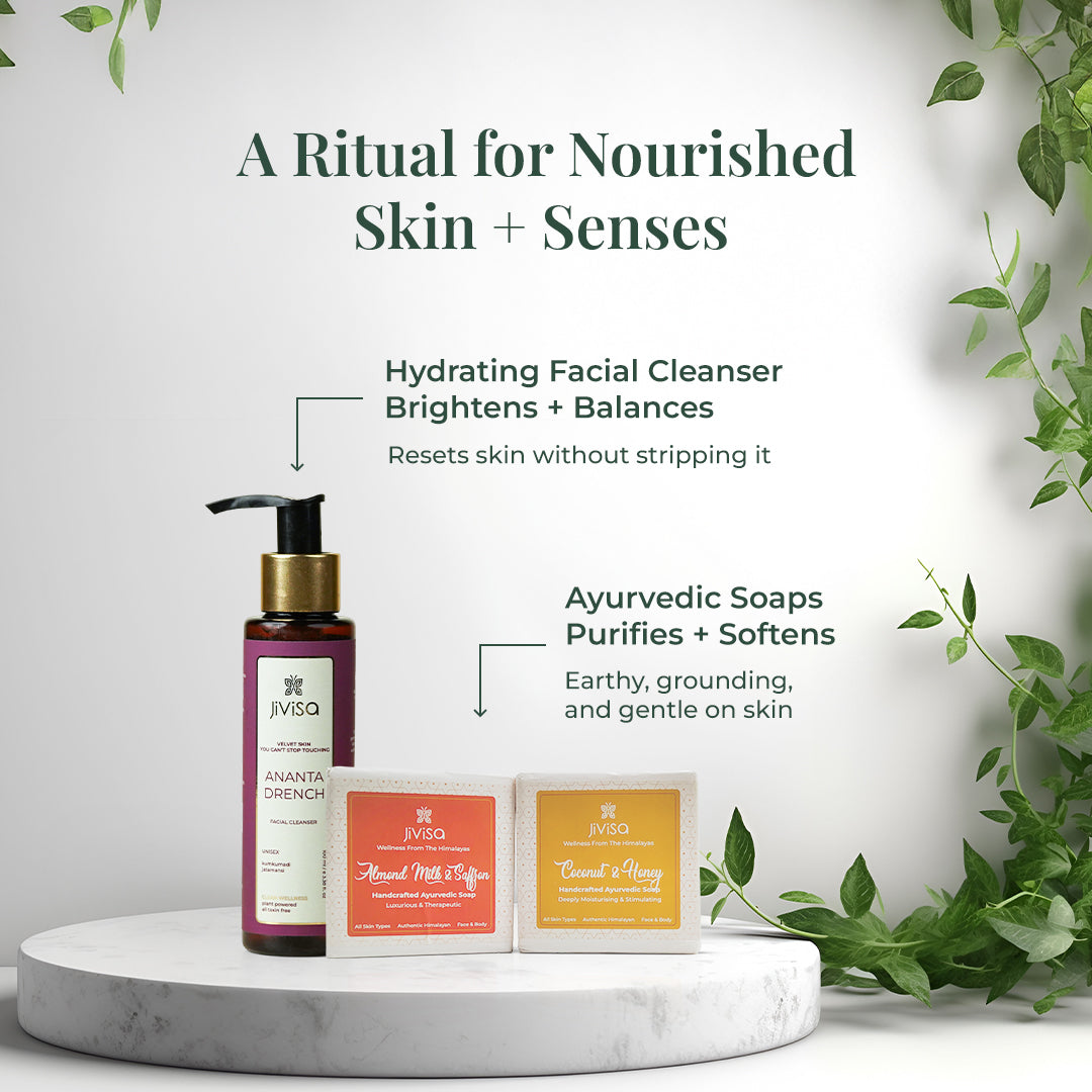 JiViSa Wake Up Ritual Gift box set placed on a marble podium with greenery in the background. Left: Ananta Drench facial cleanser described as “Hydrating Facial Cleanser – Brightens + Balances-Resets skin without stripping it” Right: JiViSa Ayurvedic soaps labeled Almond Milk & Saffron and Coconut & Honey describe as “Purifies + Softens-Earthy, grounding, and gentle on skin”. Headline reads: “A Ritual for Nourished Skin + Senses.