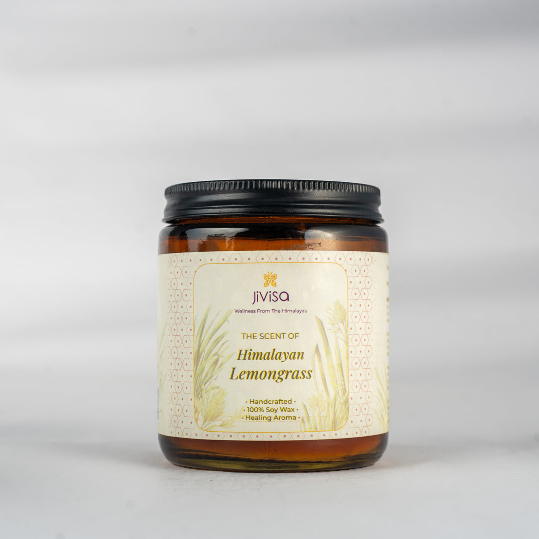 JiViSa Himalayan Lemongrass Handcrafted Soy Wax Candle 180gm in an amber glass jar with a Black tin and white label. The label reads: &quot;JiViSa Wellness From The Himalayas, THE SCENT OF Himalayan Lemongrass, Handcrafted 100% Soy Wax Candle, Healing Aroma&quot;.