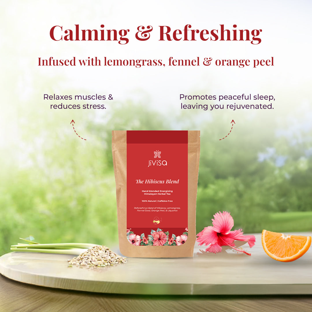 The image showcases a package of the JiViSa-The Hibiscus Blend Herbal Tea surrounded fresh lemongrass, fennel seeds, an orange slice, and a pink hibiscus flower. The tagline reads: "Calming &amp; Refreshing". The text highlights that the tea is Infused with lemongrass, fennel &amp; orange peel, and points out its benefits with curved arrows leading to the Relaxes muscles &amp; reduces stress and Promotes peaceful sleep, leaving you rejuvenated.