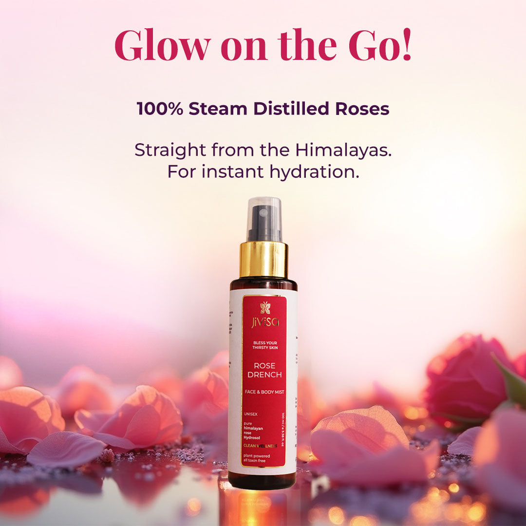 Rose Drench Face &amp; Body Mist bottle surrounded by rose petals on a soft pink background, highlighting steam-distilled Himalayan roses for instant skin hydration.