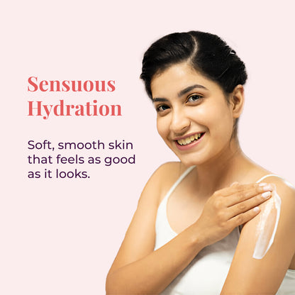 A smiling woman applying JiViSa Mridu Glaze Buttery Body Milk to their left shoulder. A visible streak of cream is on the skin. Text next to her reads &quot;Sensuous Hydration&quot; followed by the benefit, it Soft, smooth skin that feels as good as it looks.