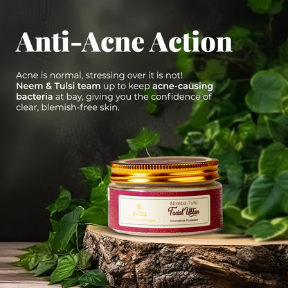 The tagline highlights &quot;Anti-Acne Action&quot; with the text Acne is normal, stressing over it is not! Neem &amp; Tulsi team up to keep acne-causing bacteria at bay, giving you the confidence of clear, blemish-free skin. Below the text there is a jar of JiViSa- Nimba Tulsi Facial Ubtan with a golden lid and a pink label. The jar sits on a piece of wood, surrounded by green leaves, against a dark background.