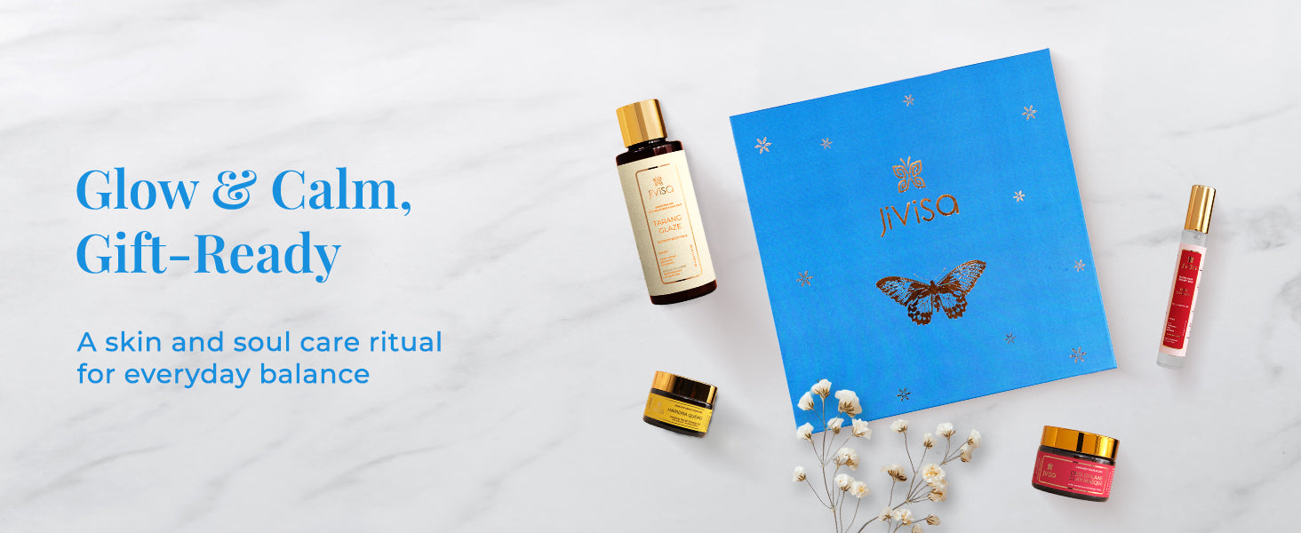 Overhead view of the JiViSa Self Care Bloom gift box with Tarang Glaze Body Milk, Rose Drench Face & Body Mist, Haridra Quench Healing Aloe Gel, and Desi Gulaab Clay Masque. The heading reads "Glow & Calm, Gift-Ready" followed by subheading "A skin and soul care ritual for everyday balance." 