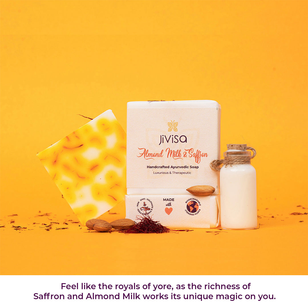Image showcases the &quot;JiViSa Almond Milk &amp; Saffron Handcrafted Ayurvedic Soap&quot; and a small bottle of almond milk on a yellow background along with loose saffron and almonds. The text below invites users to &quot;Feel like the royals of yore, as the richness of Saffron and Almond Milk works its unique magic on you&quot;. 