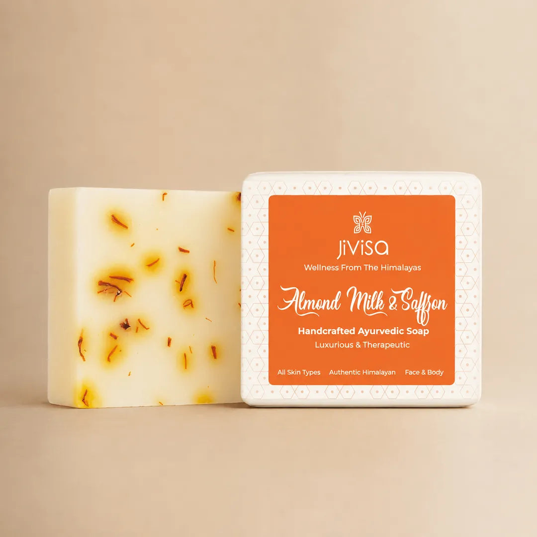 JiViSa Almond Milk and Saffron Handcrafted Ayurvedic Soap bar with saffron-flecked interior standing beside its packaging on beige background