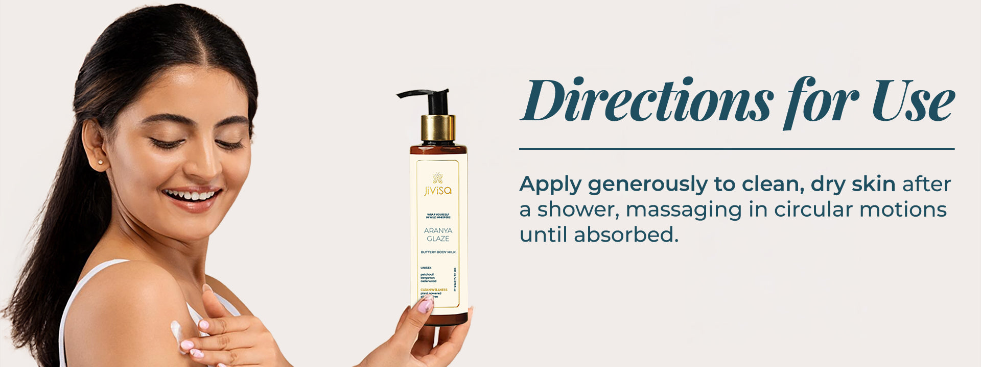 A happy woman applies JiViSa Aranya Glaze Buttery body milk to her shoulder while holding the bottle. The text reads: “Directions for Use” followed by instructions: Apply generously to clean, dry skin after a shower, massaging in circular motions until absorbed.