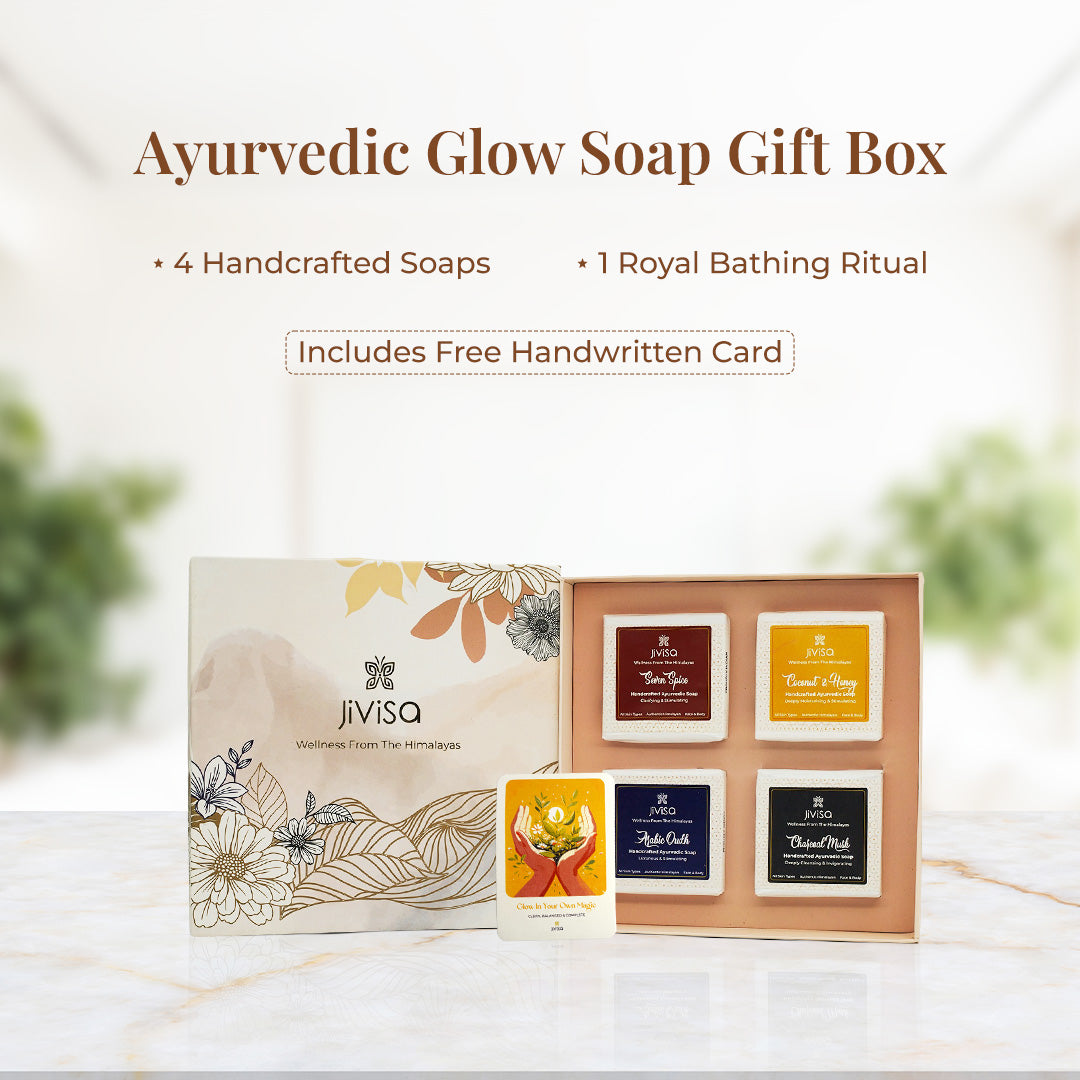 Tagline reads: &quot;Ayurvedic Glow Soap Gift Box – 4 Handcrafted Soaps | 1 Royal Bathing Ritual. Includes Free Handwritten Card&quot; followed by a soft, elegant setup featuring JiViSa’s floral gift box opened to reveal four JiViSa handmade soaps: Seven Spice, Coconut &amp; Honey, Arabic Oudh, and Charcoal Musk. A bright yellow illustrated handwritten card adds a personal touch to this luxurious bathing ritual.