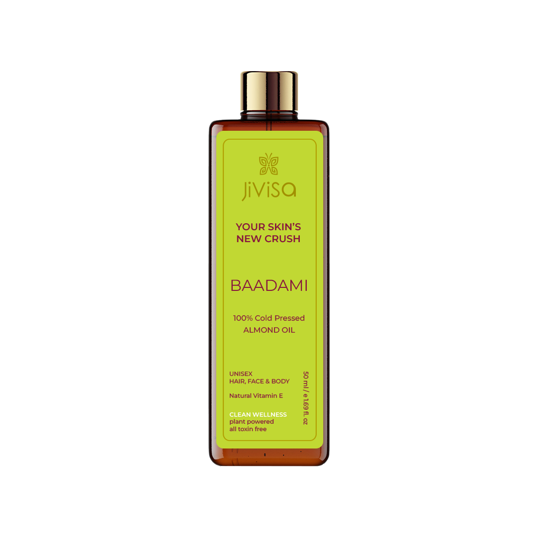 Image of JiViSa Badami 100% Cold Pressed Almond Oil, a 50 ml amber bottle with a gold cap. The front label displays the product name 'Badami 100% Cold Pressed Almond Oil' and its key features for hair, face, and body. It emphasizes the natural Vitamin E content and clean wellness attributes.