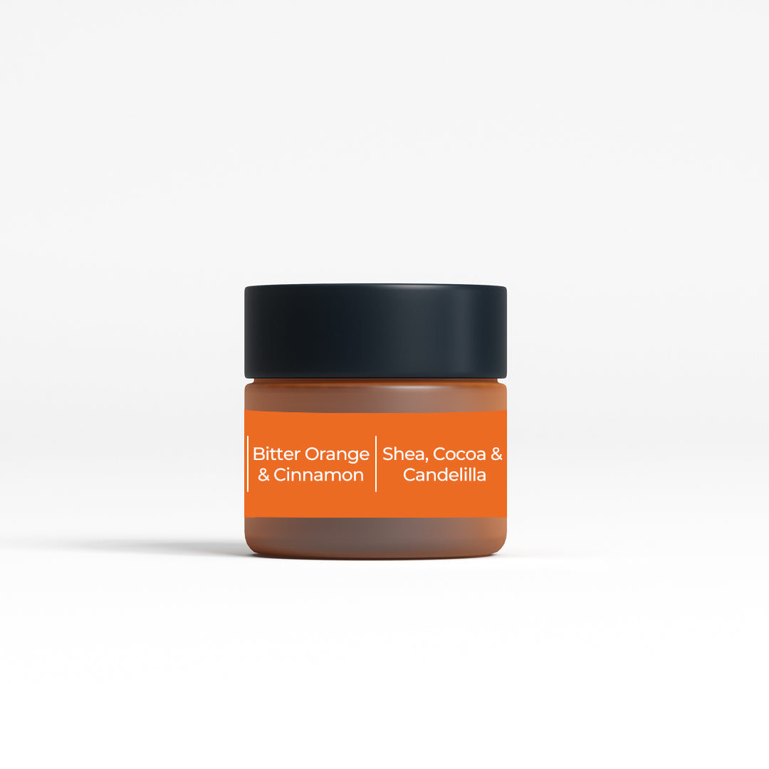 Back view of JiViSa Bitter Orange & Cinnamon  Peptide Lip Lop lip balm jar. The label highlights the key ingredients: Shea, Cocoa, and Candelilla, emphasizing the natural and nourishing components of the lip balm. The jar's design complements its premium and effective formulation, suitable for everyday use.