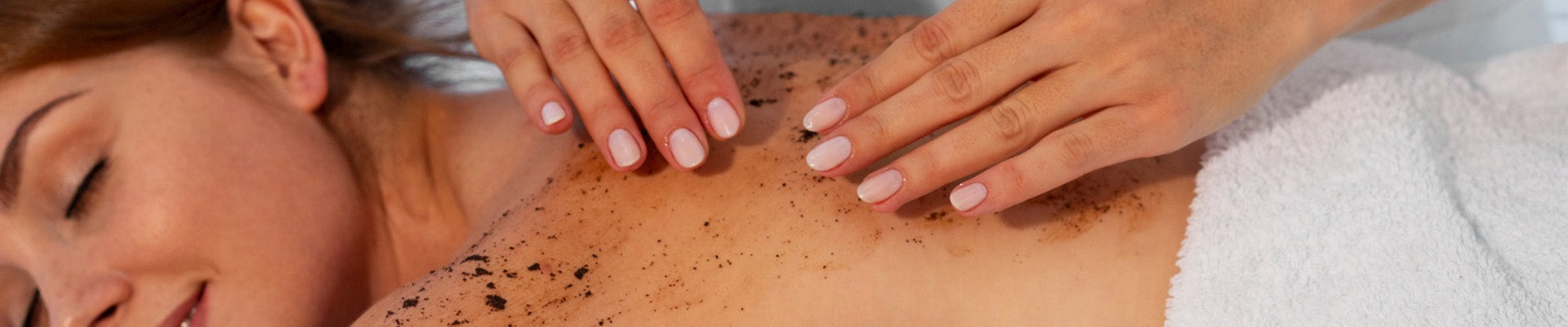 Close-up of a spa therapist applying a JiViSa herbal body masque scrub on a woman’s back during a relaxing spa treatment. The grainy exfoliating paste is being gently massaged over the shoulders, highlighting deep exfoliation, skin polishing, detoxifying body care, and a clean wellness ritual designed to smooth, brighten, and nourish the skin.