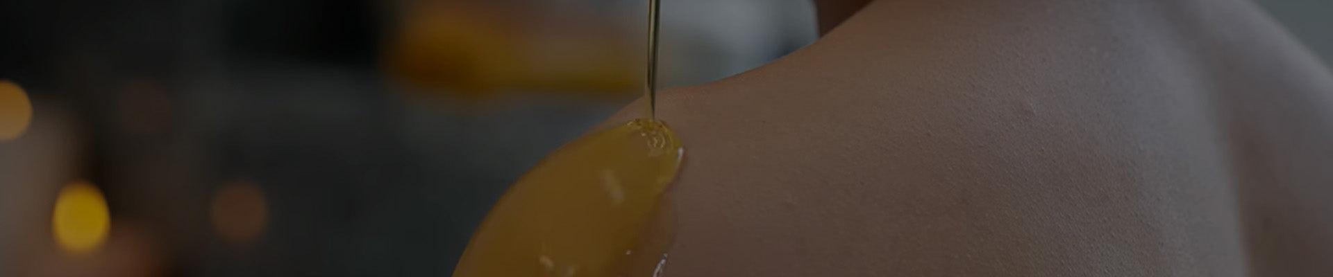 Close-up of oil being poured onto skin.