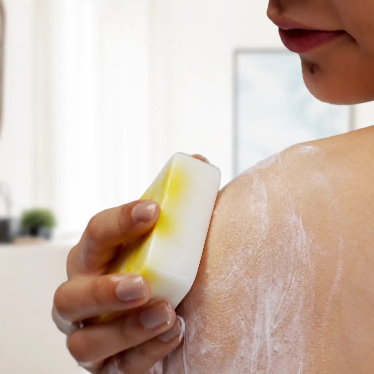 Woman applying JiViSa natural bathing bar to shoulder – Body Care category