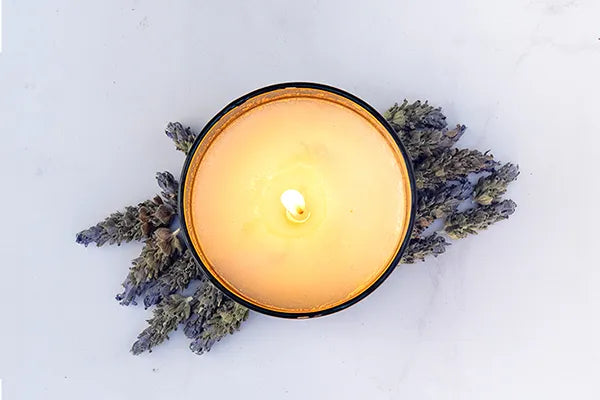 Lit JiViSa soy wax candle surrounded by dried lavender – Candles category