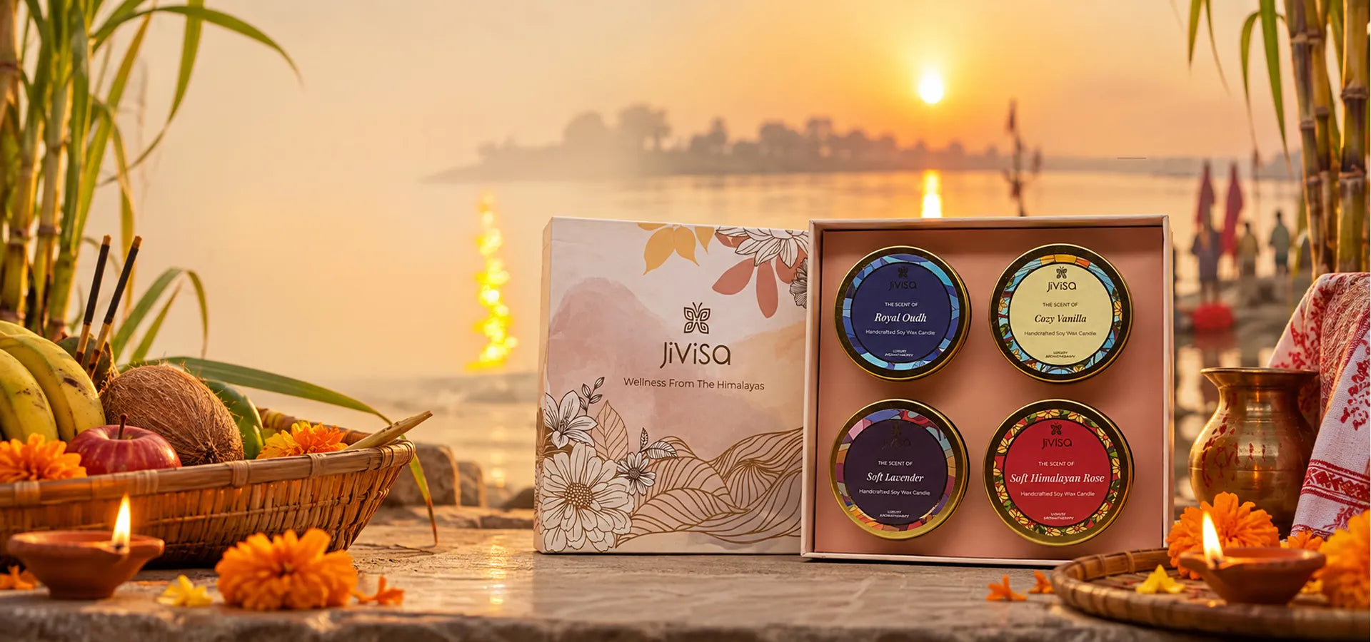JiViSa 'Wellness From The Himalayas' candle gift set with Royal Oudh, Cozy Vanilla, Soft Lavender, and Himalayan Rose scents, styled riverside at sunset for Chhath Puja.
