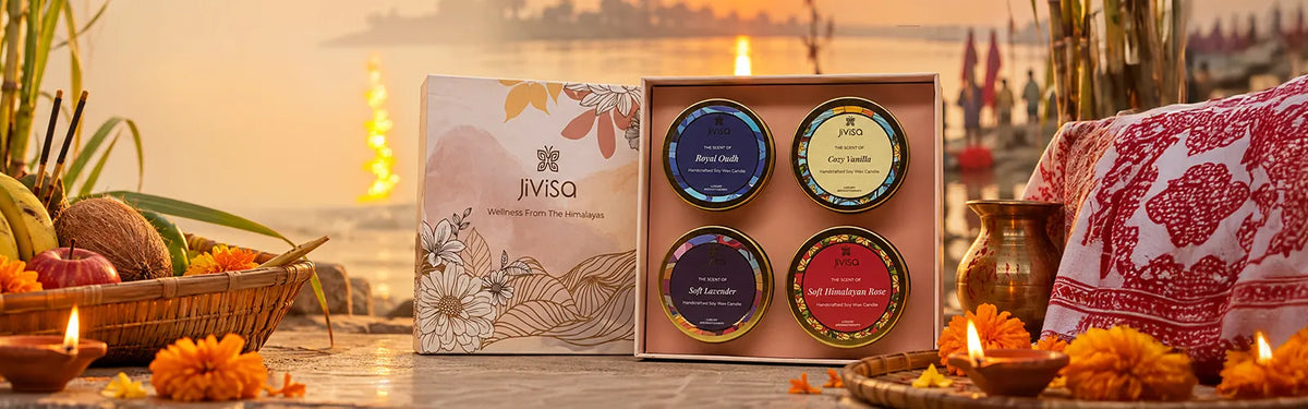 JiViSa 'Wellness From The Himalayas' candle gift set with Royal Oudh, Cozy Vanilla, Soft Lavender, and Himalayan Rose scents, styled riverside at sunset for Chhath Puja.