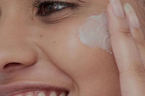 Woman applying JiViSa face cream to cheek – Face Care category