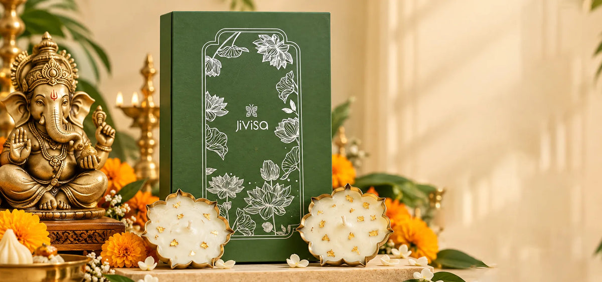 JiViSa Urli gift box with two gold-flecked lotus-shaped candles, styled beside a Ganesha idol and marigold flowers for Ganesh Chaturthi.