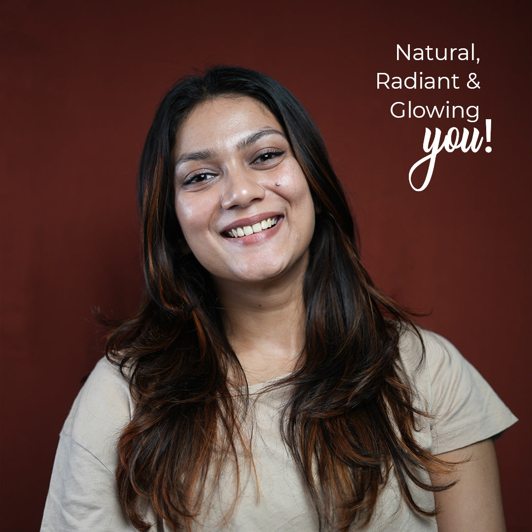 A smiling woman with warm complexion looks directly at the camera. Her skin appears radiant and healthy. The background is a solid maroon color. White text in the upper right corner reads &quot;Natural, Radiant &amp; Glowing you!&quot;