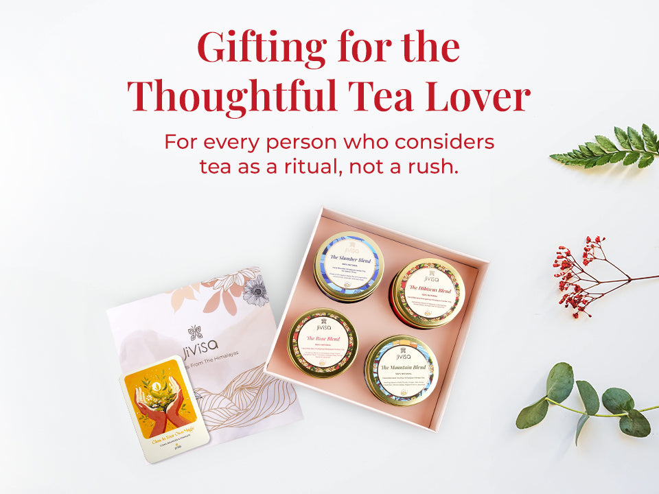 Flat lay of the JiViSa Himalayan Discovery Tea Gift Box, open to display four variant of JiViSa tea blends: The Hibiscus Blend, The Slumber Blend, The Rose Blend, and The Mountain Blend. The floral-illustrated box is paired with a handwritten personalized card. Tagline reads: "Gifting for the Thoughtful Tea Lover." Supporting text: For every person who considers tea as a ritual, not a rush.
