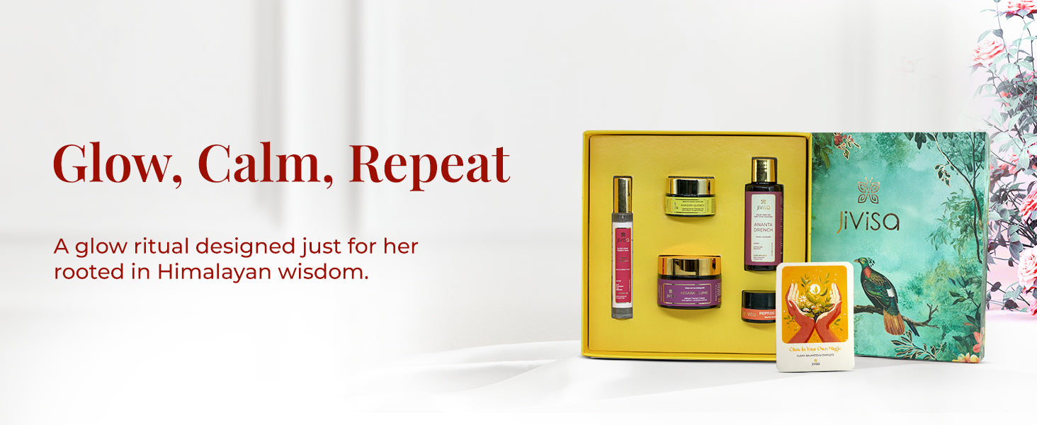 JiViSa Himalayan Glow Ritual For Her gift box open to reveal five JiViSa products—Ananta Drench Facial Cleanser, Rose Drench Face & Body Mist, Kesara Illume Velvet Facial Creme, Haridra Quench Healing Facial Therapy Gel, and Peptide Lip Pop—paired with a gift card arranged in a yellow tray. Placed beside its nature-inspired green box featuring a bird and forest foliage. Text on the left reads: “Glow, Calm, Repeat.” followed by supporting text: A glow ritual designed just for her rooted in Himalayan wisdom.