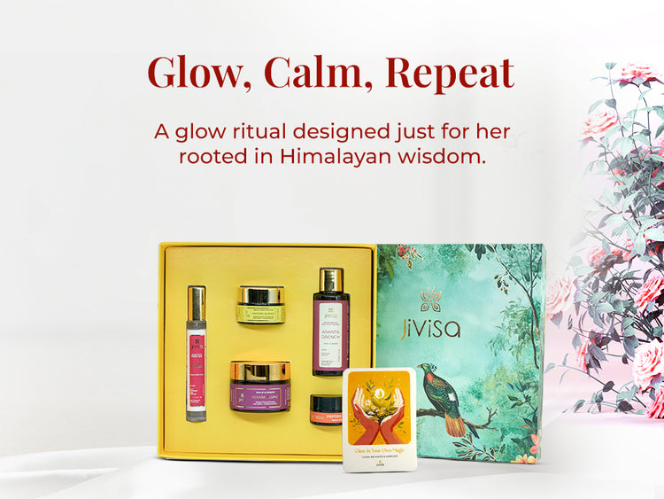 JiViSa Himalayan Glow Ritual For Her gift box open to reveal five JiViSa products—Ananta Drench Facial Cleanser, Rose Drench Face & Body Mist, Kesara Illume Velvet Facial Creme, Haridra Quench Healing Facial Therapy Gel, and Peptide Lip Pop—paired with a gift card arranged in a yellow tray. Placed beside its nature-inspired green box featuring a bird and forest foliage. Text on the left reads: “Glow, Calm, Repeat.” followed by supporting text: A glow ritual designed just for her rooted in Himalayan wisdom.

