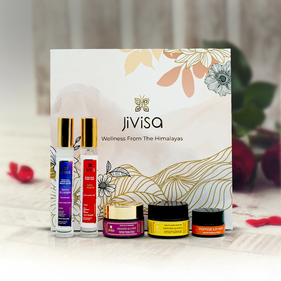 JiViSa Himalayan Glow Gift Set.
The box includes several bottles and jars, arranged in front of a white box decorated with floral line art. The products include JiViSa-Raina Slumber Pillow Mist, JiViSa-Rose Drench Face &amp; Body Mist, JiViSa- Kesara Illume Velvet Facial Creme, JiViSa- Haridra Quench Healing Facial Therapy Gel and JiViSa- Orange &amp; Cinnamon Peptide Lip Pop.