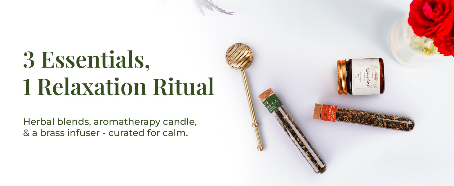 Flat lay of JiViSa Brew & Bliss Gift Set products—JiViSa Tulsi and Mountain  herbal tea blend glass tubes, JiViSa Cozy Vanilla aromatherapy soy wax candle, and brass tea infuser—arranged on a white background with red flowers. Tagline on the left reads: “3 Essentials, 1 Relaxation Ritual”, followed by text: Herbal blends, aromatherapy candle, & a brass infuser - curated for calm.