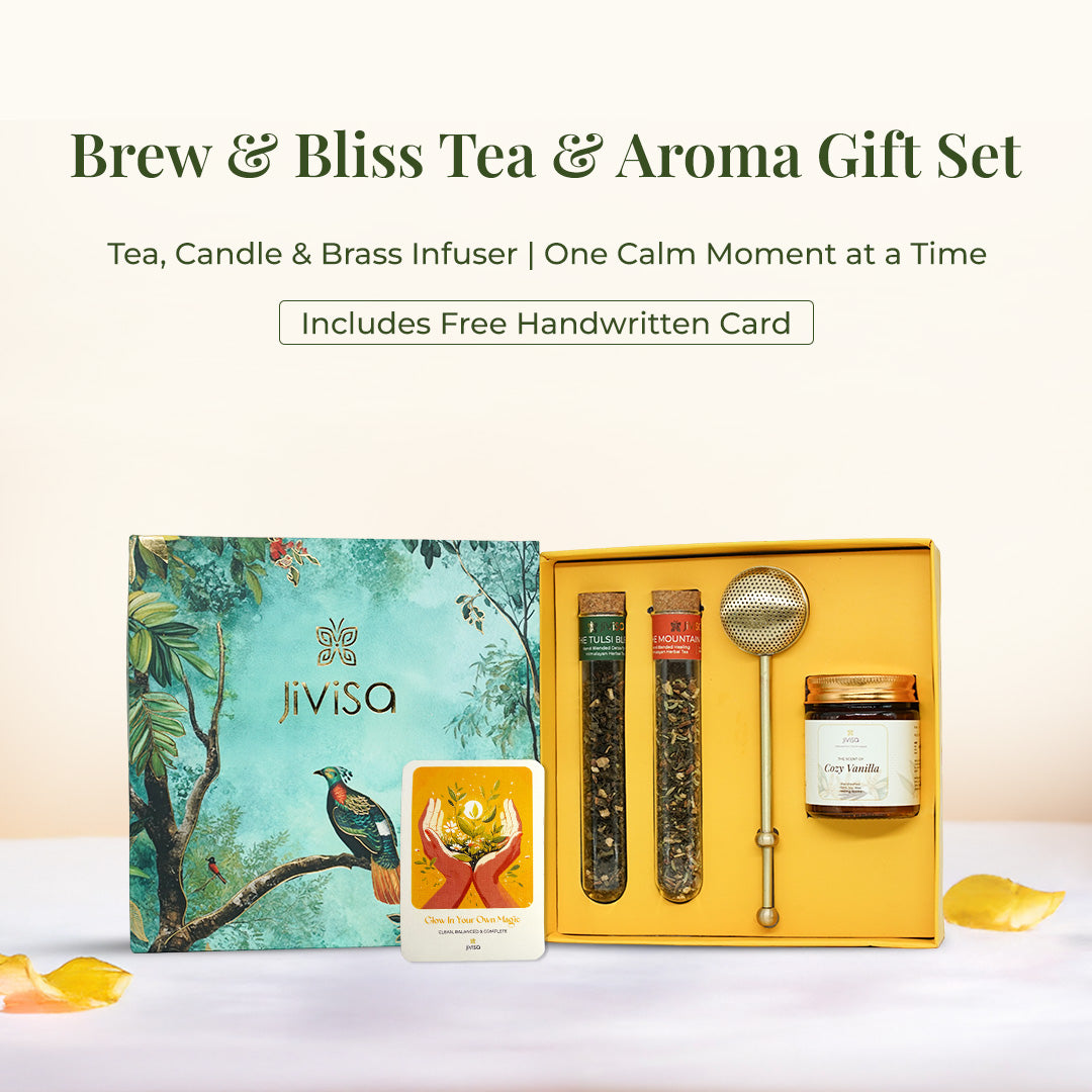 JiViSa Brew &amp; Bliss Tea &amp; Aroma Gift Set featuring two herbal tea blends glass tubes-Tulsi and Mountain blend, a brass infuser, Cozy Vanilla candle glass jar, and a glow affirmation card. All items are arranged in a yellow tray beside its green nature-inspired gift box with bird and foliage illustration. Top text reads: “Brew &amp; Bliss Tea &amp; Aroma Gift Set” followed by: “Tea, Candle &amp; Brass Infuser | One Calm Moment at a Time.” Highlighted badge reads: “Includes Free Handwritten Card.”
