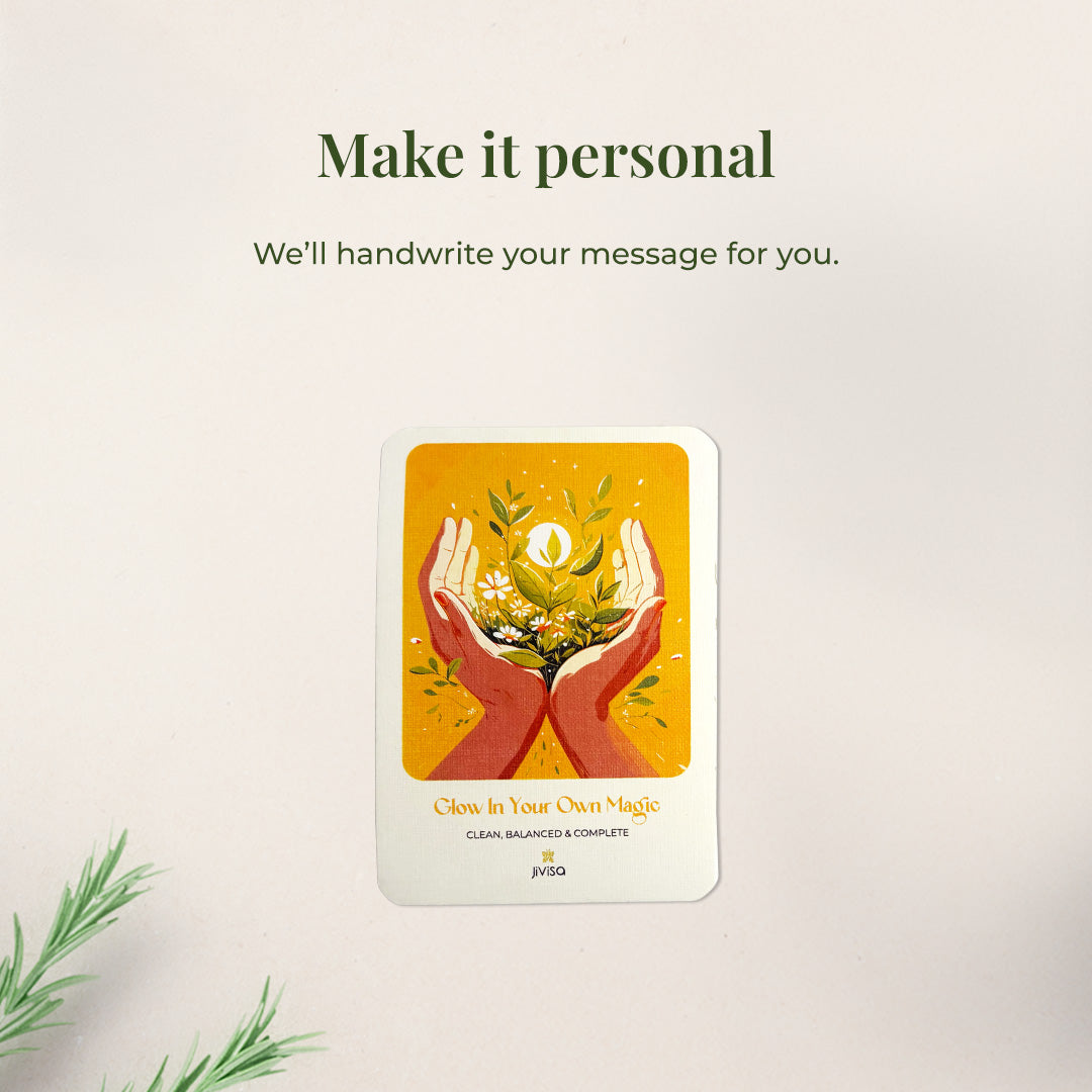 &quot;Make it personal – We’ll handwrite your message for you.&quot; A handwritten card with warm yellow and orange tones shows two hands holding blooming herbs with a glowing sun. Placed on a white surface, the image emphasizes the personal, heartfelt gifting experience JiViSa offers.