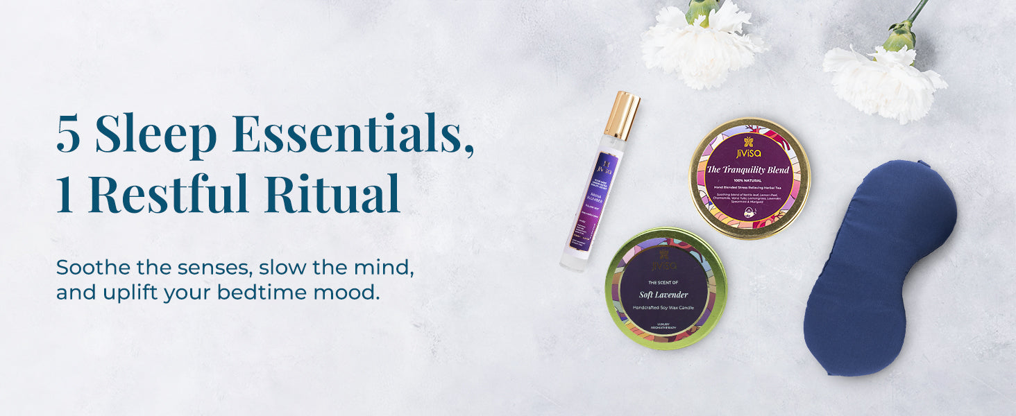 Top view of JiViSa Dreamscape Gift Set essentials on a soft background with white flowers. Includes a navy blue soft eye mask, JiViSa Tranquility Blend tea tin, JiViSa Soft Lavender soy wax candle, and a JiViSa Raina Slumber pillow mist. Tagline: "5 Sleep Essentials, 1 Restful Ritual." Supporting text: Soothe the senses, slow the mind, and uplift your bedtime mood.