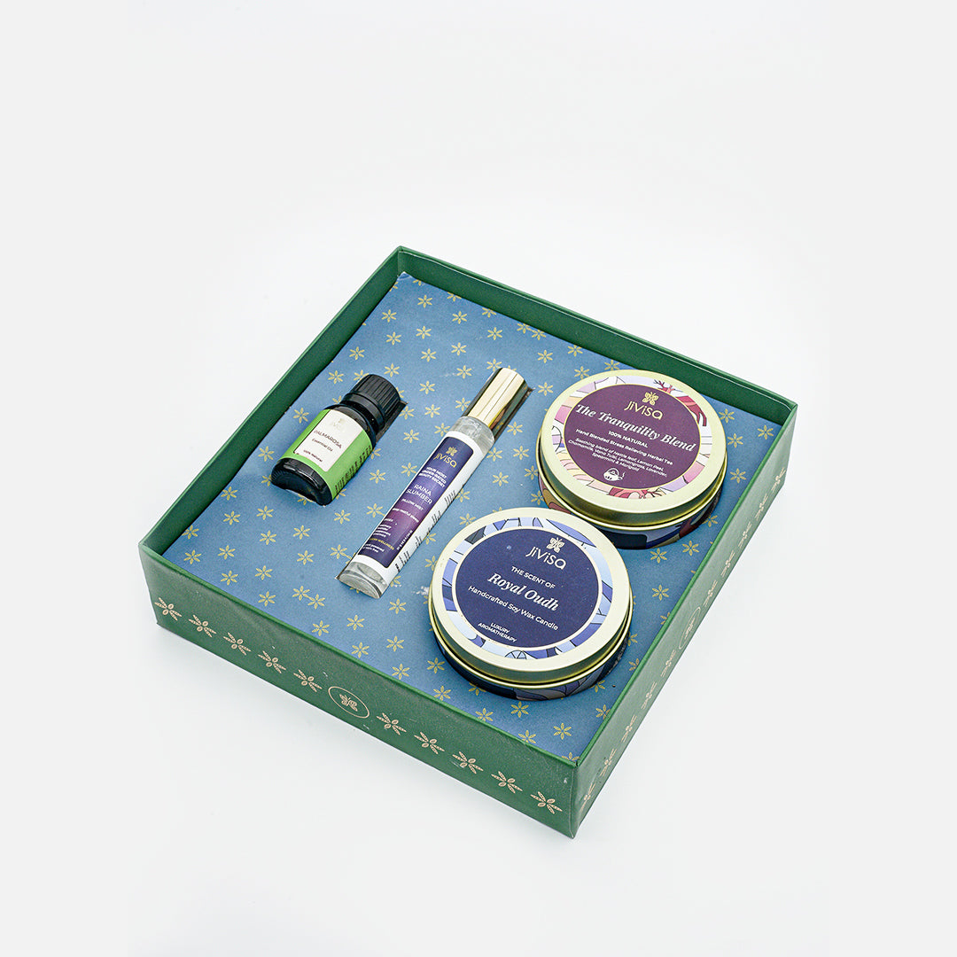 Top View of JiViSa Dreamscape Relaxation Gift Set featuring the JiViSa Tranquility Blend Stress Relief Herbal Tea, the Royal Oudh Premium Soy Wax Candle, a bottle of Palmarosa Essential Oil, and the soothing Raina Slumber Pillow Mist.