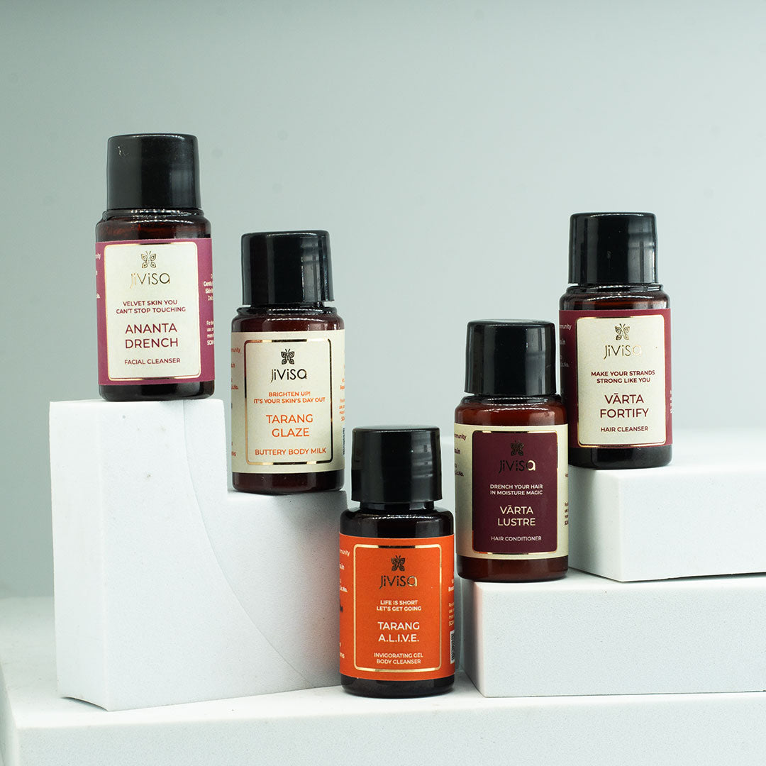 JiViSa Glow Kit – 5-piece skincare set including Ananta Drench Face Cleanser, Tarang Body Cleanser, Mridu Body Milk, Kesara Illume Moisturiser, and Rose &amp; Lavender Peptide Lip Salve, elegantly arranged with natural ingredients like saffron, lavender, and jatamansi in the background.
