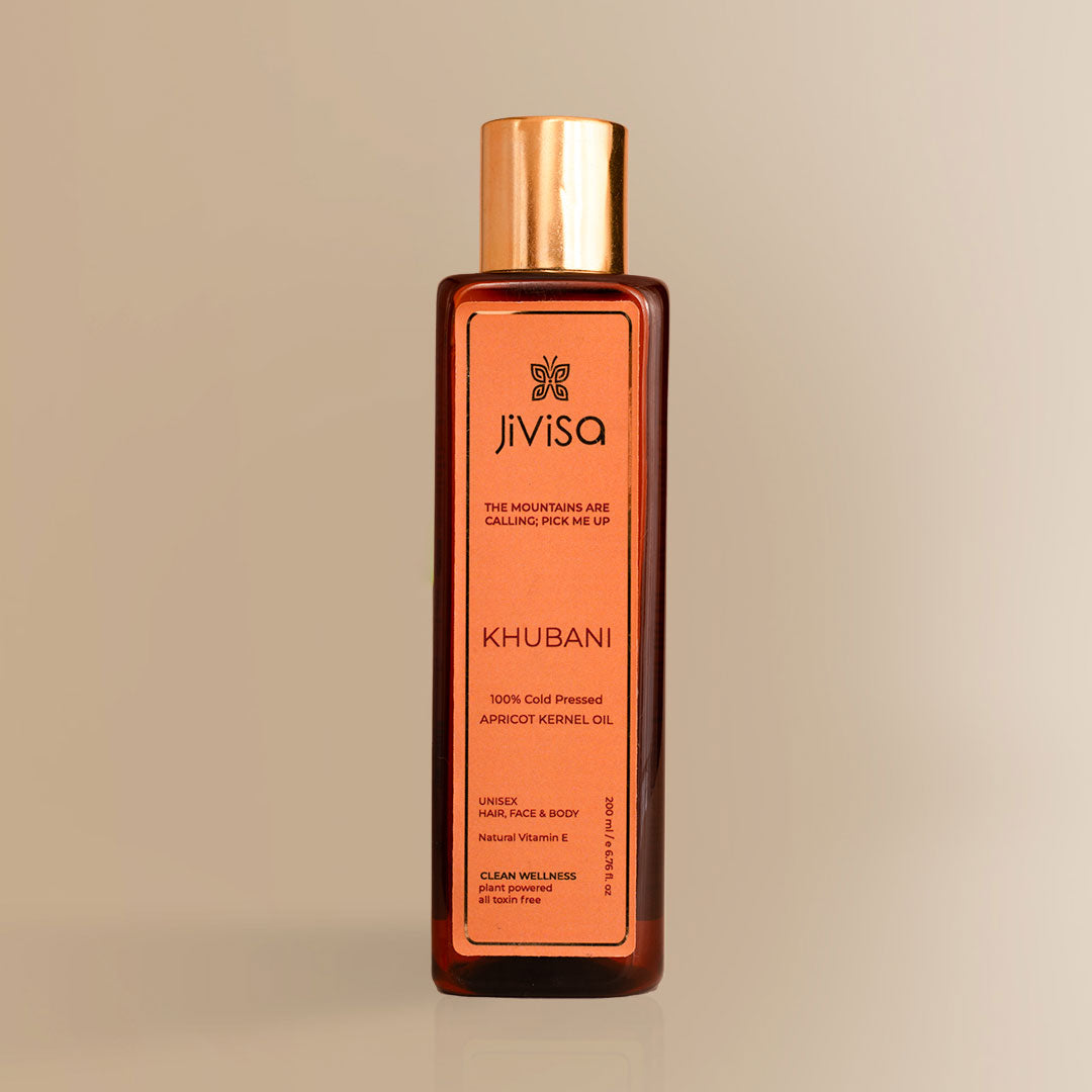 JiViSa Khubani Apricot Kernel Oil bottle with gold cap on beige background.