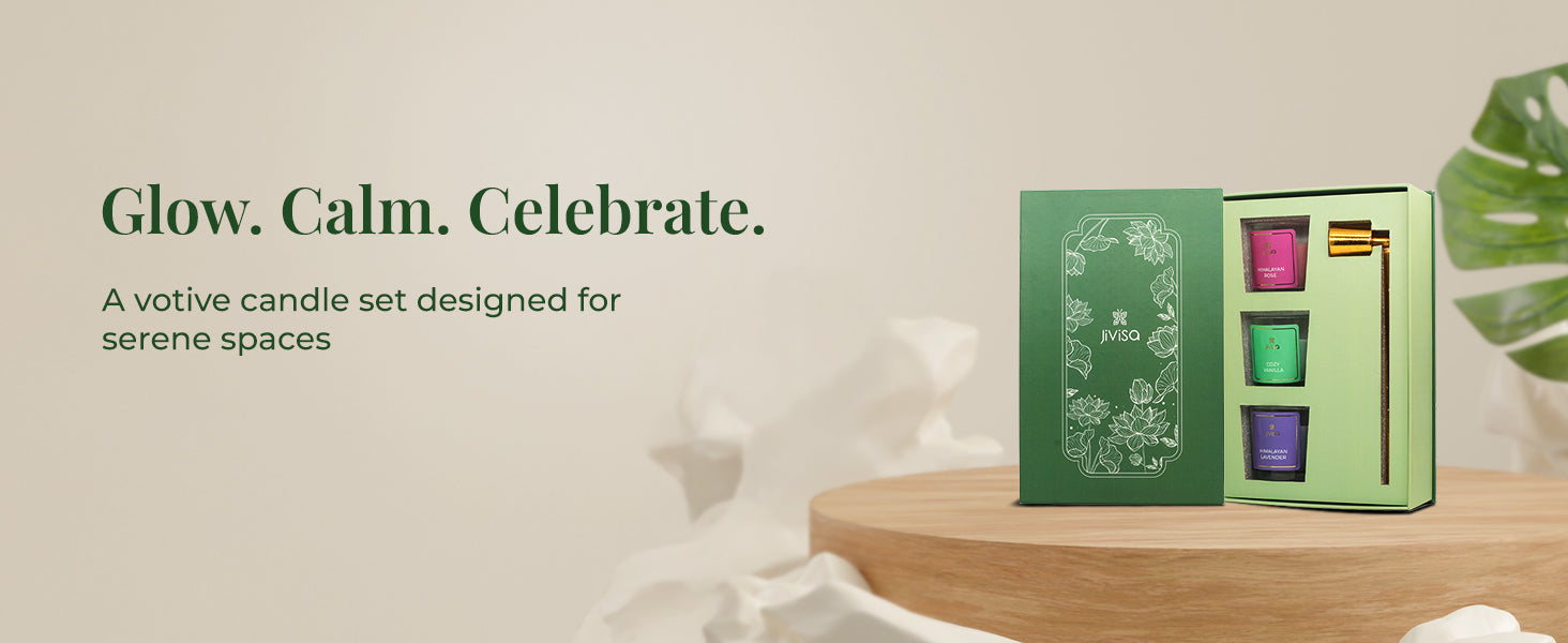 An open JiViSa Lotus Light Votive Candle Gift Set placed on a wooden table, featuring three artisanal votive candles — Himalayan Rose, Himalayan Lavender, and Cozy Vanilla — along with a handcrafted brass snuffer. The tagline reads "Glow. Calm. Celebrate." with a supporting text 'A votive candle set designed for serene spaces'.