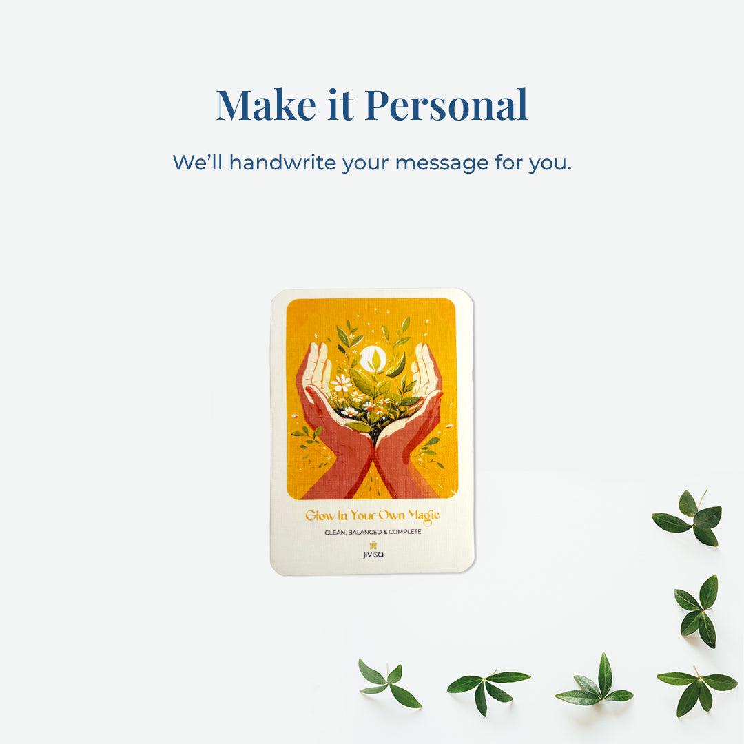&quot;Make it personal – We’ll handwrite your message for you.&quot; A handwritten card with warm yellow and orange tones shows two hands holding blooming herbs with a glowing sun. Placed on a white surface, the image emphasizes the personal, heartfelt gifting experience JiViSa offers.
