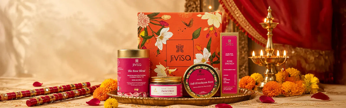 JiViSa Navratri gift set with Rose Blend tea, Facial Ubtan, Himalayan Rose candle, and Rose Drench mist, styled with dandiya sticks, marigolds, and diyas.