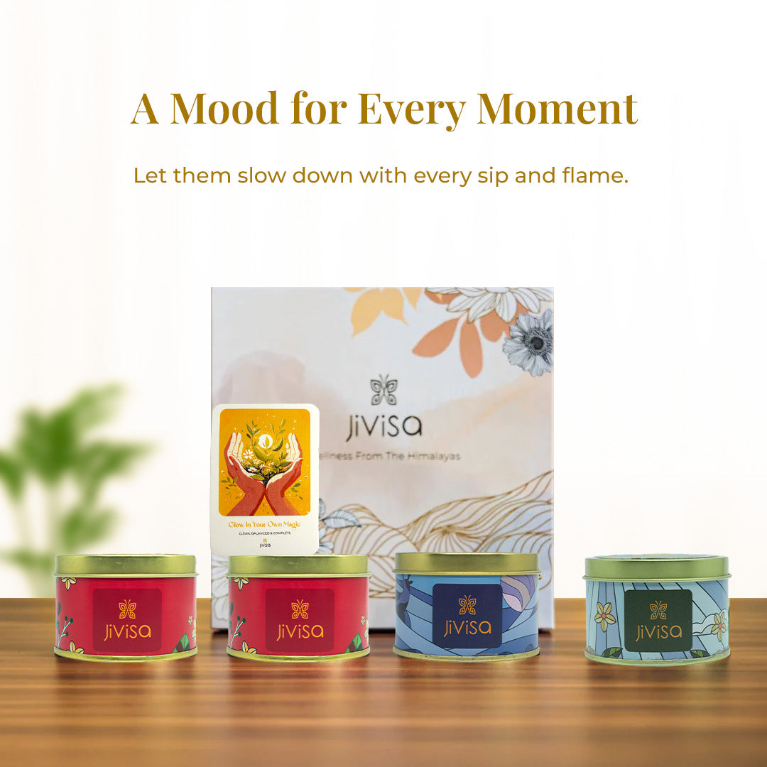 Tagline reads: &quot;A Mood for Every Moment – Let them slow down with every sip and flame&quot; followed by a warm, minimal setup with the floral JiViSa box in the background and the four tins placed in the foreground. A yellow “Glow In Your Own Magic” handwritten gift card completes the soulful composition.