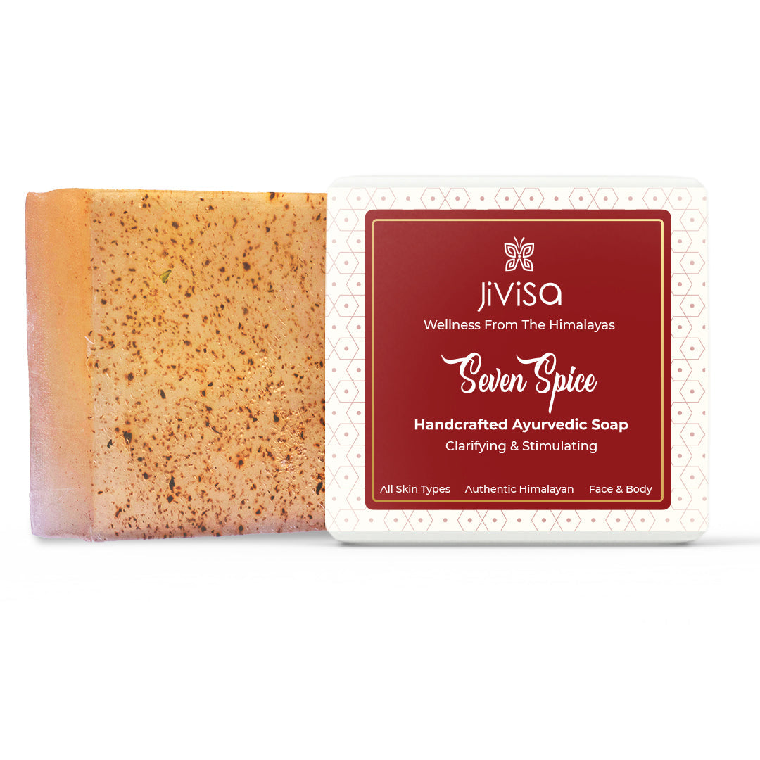 JiViSa Seven Spice Ayurvedic Handmade Soap bar placed beside its box packaging, which features a rich red label with white decorative border. The text on the label reads: “JiViSa Wellness From The Himalayas: Seven Spice Handcrafted Ayurvedic Soap -Clarifying &amp; Stimulating for All Skin Types| Authentic Himalayan| Face &amp; Body.
