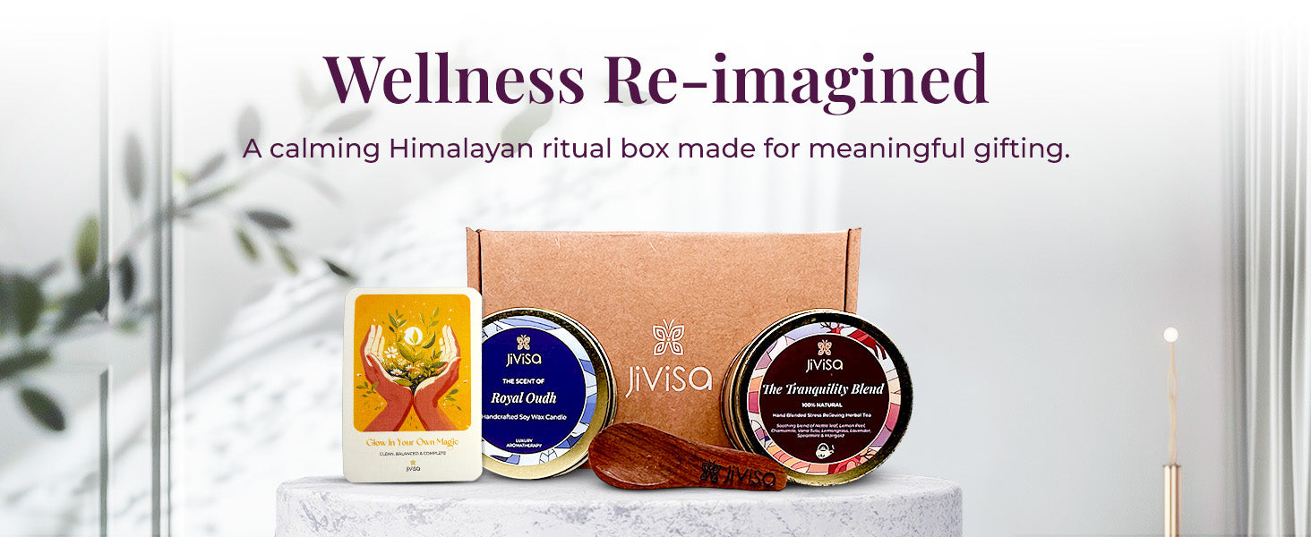 JiViSa Tranquil Himalayan Gift Box featuring Royal Oudh soy wax candle, The Tranquility Blend herbal tea, a wooden spoon, and an affirmation card, arranged in front of a kraft box. Tagline above reads: “Wellness Re-imagined”, followed by subtext: 'A calming JiViSa Tranquil Himalayan ritual box made for meaningful gifting.'